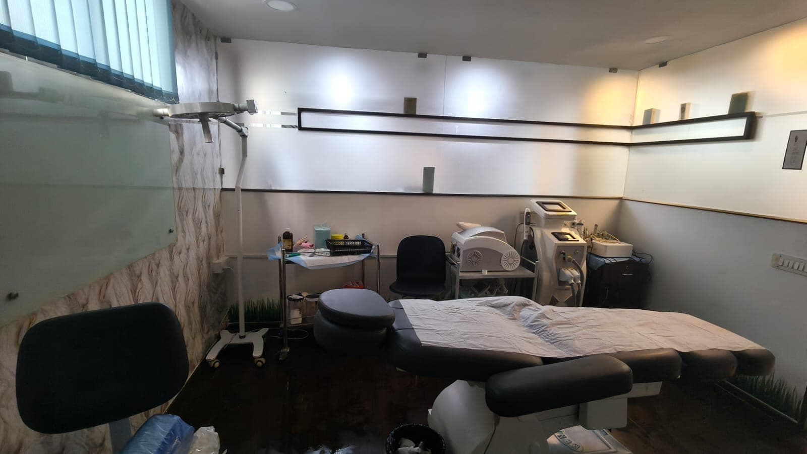 Modern procedure suite at Crown Celebrity Aesthetic equipped with advanced laser consoles and treatment couch